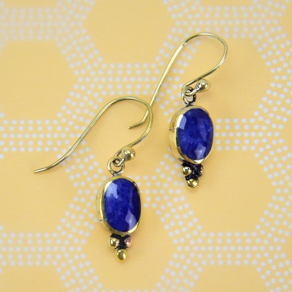 Gold earrings with A oval stone, that is a bright blue.