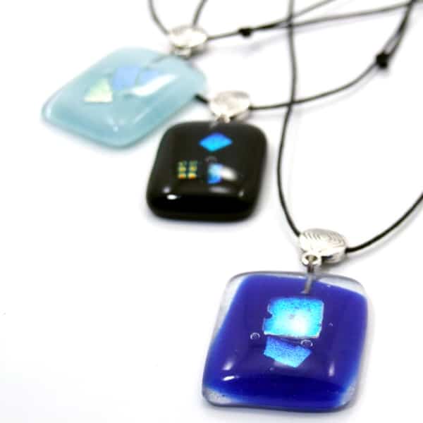 A picture of the dichroic glass necklace, made from glass and comes in a verity of different colors, the colors in this picture are, blue, black, and sky blue.