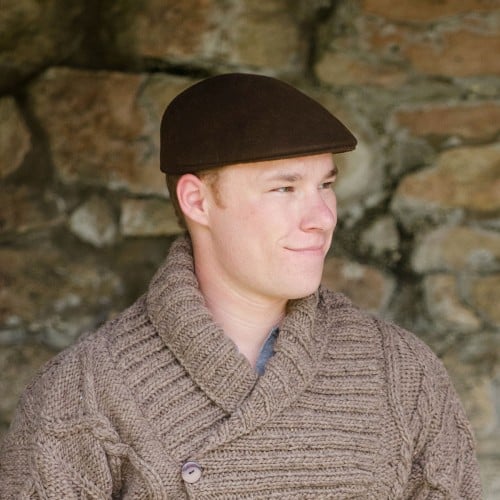 A young man wearing a brown wool flat cap