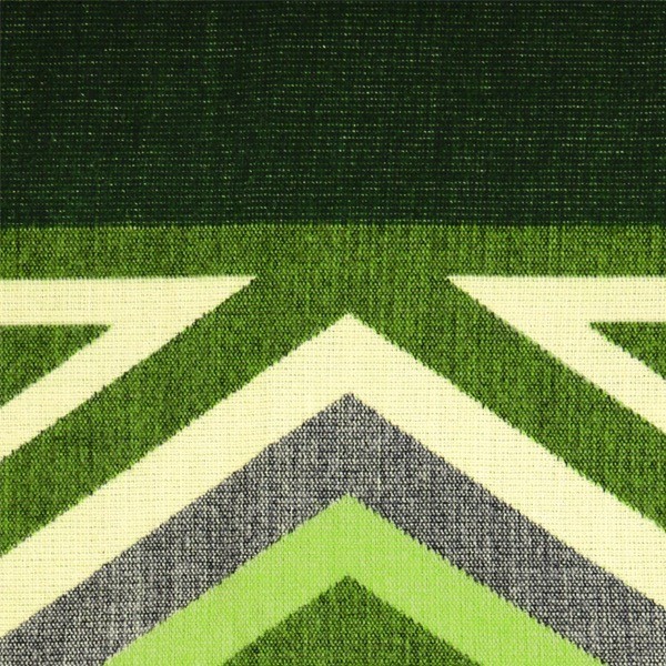 A close up of the comodo poncho, showing colors and designs, this one is dark green, green, and white