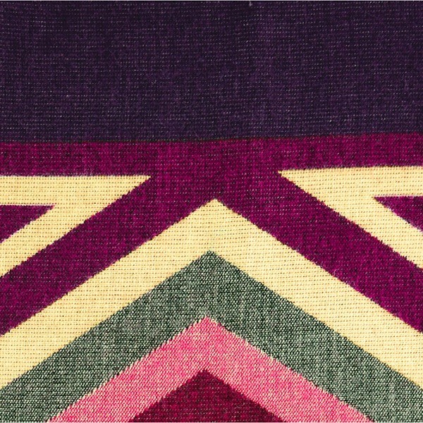 A close up of the comodo poncho, showing colors and designs, this one is purple, magenta, and white