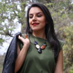 A young women wearing the cinco tagua necklace, has five tagua stones on a necklace, comes in a verity of colors.