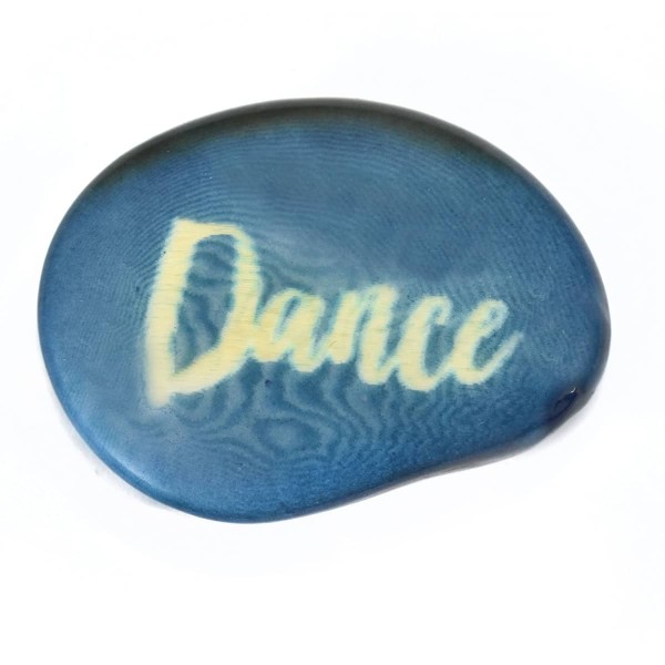 A tagua seed that says dance on it