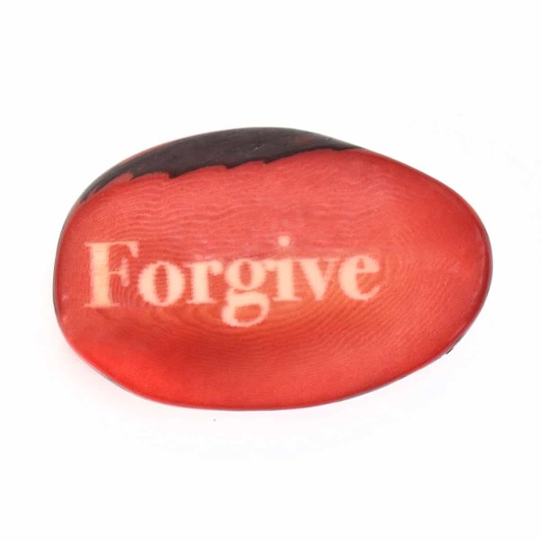 A tagua seed that says forgive on it