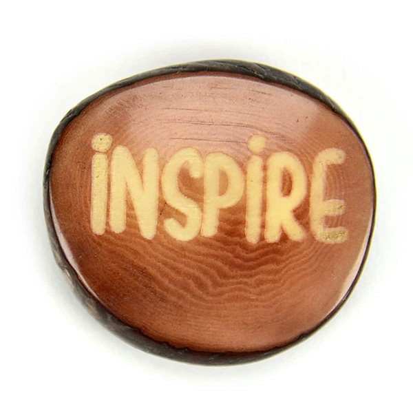 A tagua seed that says inspire on it