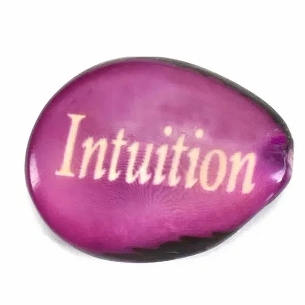 A tagua seed that says intuition on it