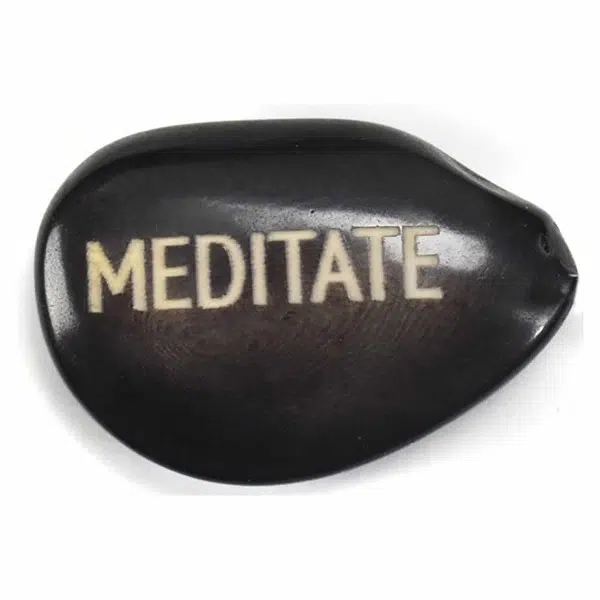 A tagua seed that says Meditate on it