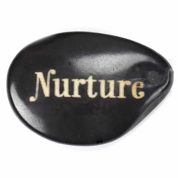 A tagua seed that says nurture on it