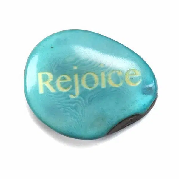 A tagua seed that says rejoice on it