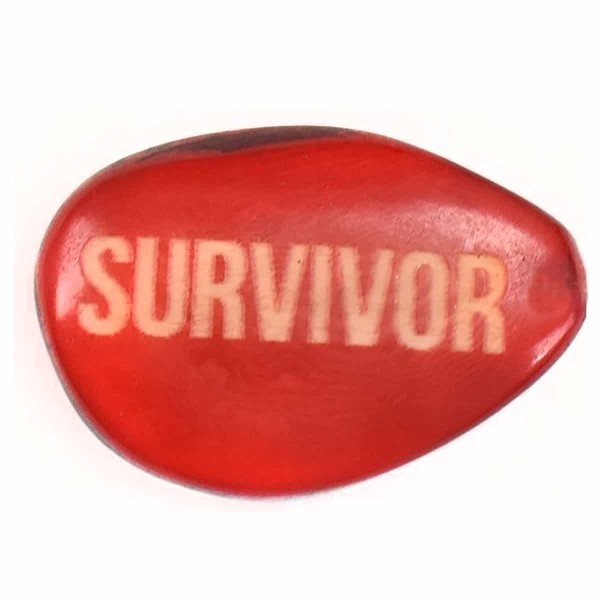 A tagua seed that says survivor on it