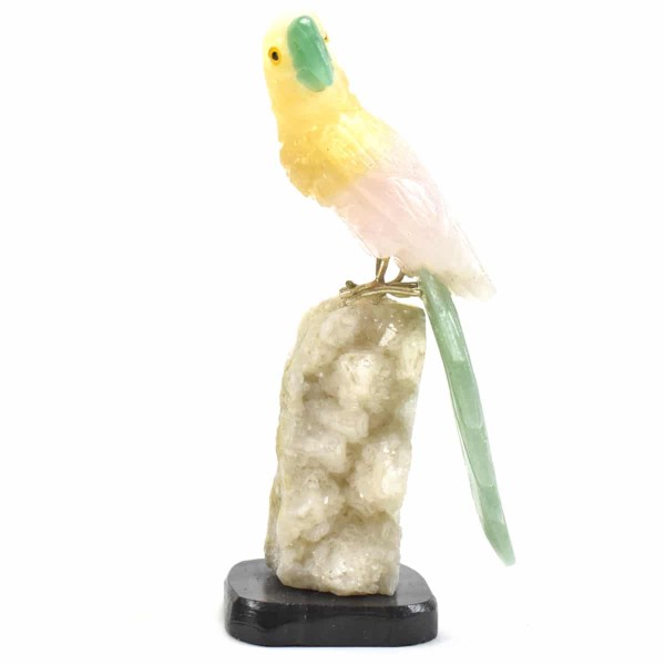 a parrot sitting on a semi precious stone parrot, the colors of the stones are, white with brown.