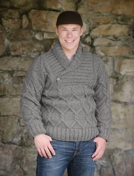 A young man wearing the cowl neck wool sweater, the sweater is made from sheep wool, and is available in navy and charcoal