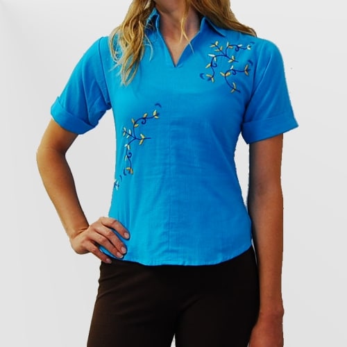 A short sleeved shirt with hand embroidered floral design s on it