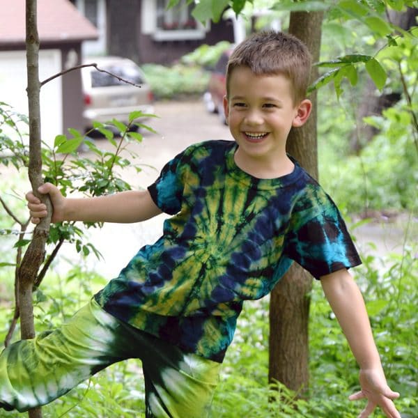 A kid showing off the tie dyed t-shirt and pants