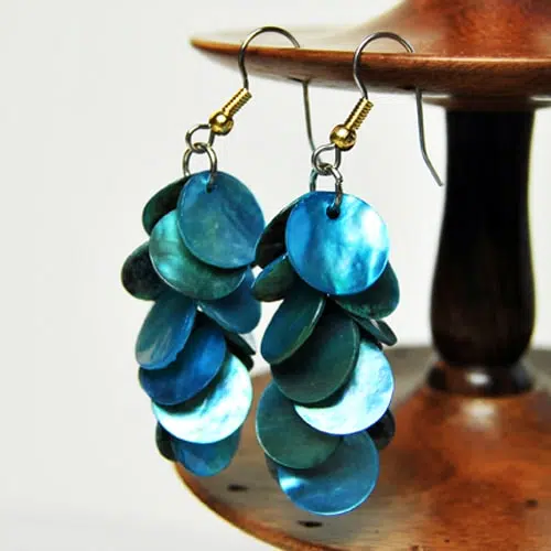 A close up of the mother of pearl cascade earrings, coming in the color of turquoise.