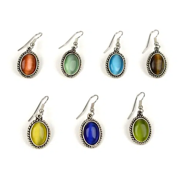 A picture of a bunch of different cats eye earrings, these colors are, red, lime, turquoise, brown, yellow, blue, and green.