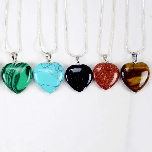 A picture of five different heart necklaces, coming in the colors of, green, turquoise, black, red, and brown.