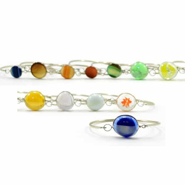A picture of a bunch of different colors that the top latch bracelet comes in, those colors are, blue, brown, orange, red, green, lime, bright yellow, yellow, and white.