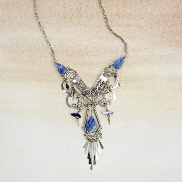A picture of stone chandelier necklace made out of a blue stone.