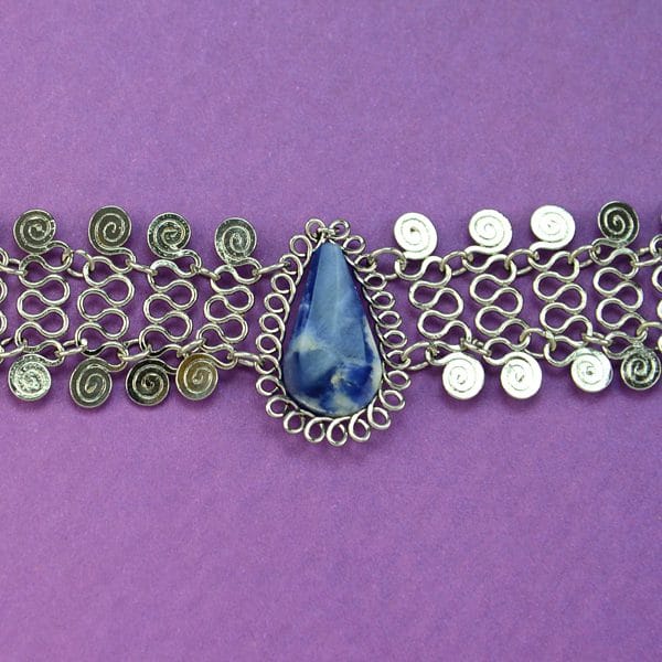 A picture of A alpaca mesh necklace with a semi precious stone, the color of the stone is blue.