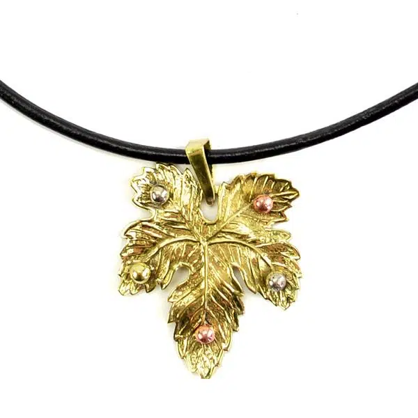 A picture of a golden maple leafs hanging on a necklace.