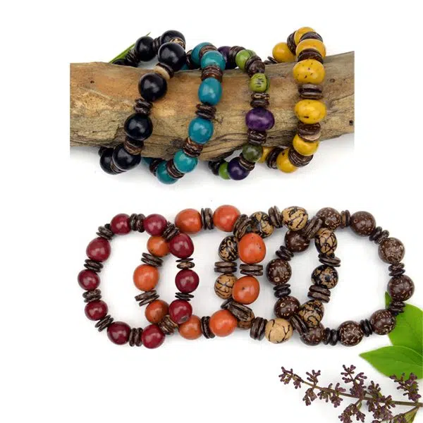 A bunch of different colored coco pambil bracelets, those colors are, blakc, turquoise, green/purple, yellow, red, orange, tan, and brown.