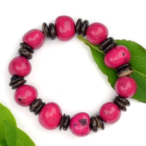 A bright pink bracelet, made from dyed pambil seeds and coconuts
