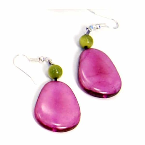 A close up of the tagua crown earrings, this pair of earrings is bright pink.
