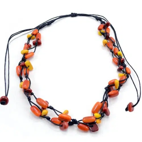 A necklace that is knotted and has richly dyed tagua beads.