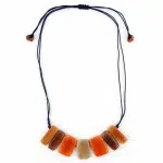 A picture of a gradient necklace, has tagua plaques dyed in similar colors, the colors go from light to dark.