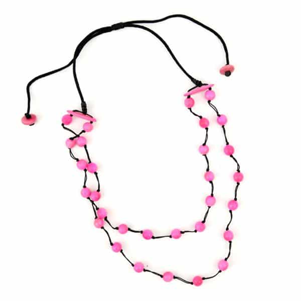 A picture of a daub necklace, made out of tagua pearls and comes in a verity of colors, the color in this picture is pink.
