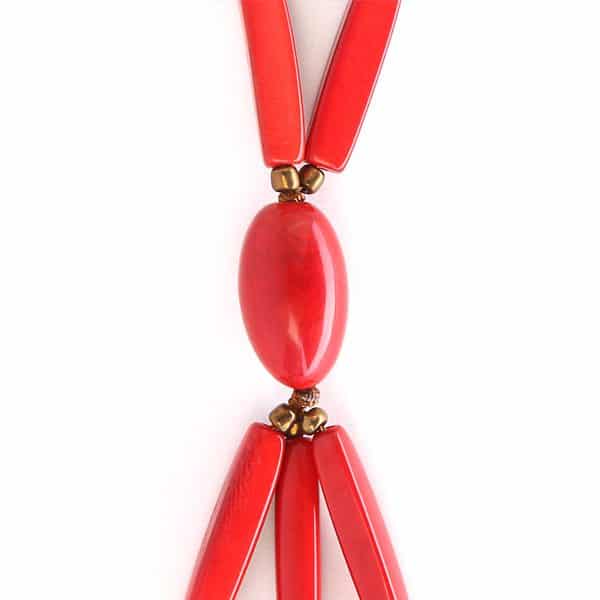 A close up picture of the red runway necklace, showing its gem at the bottom of the necklace.