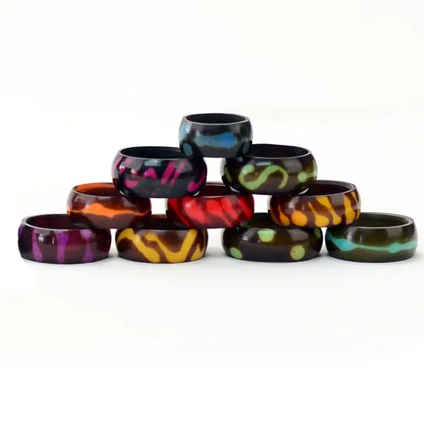 A picture of colorful tagua ring bands, comes with designs on the side of the ring that has been colored.