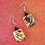 Two earrings that have been made from tagua seeds, that has a neutral look.