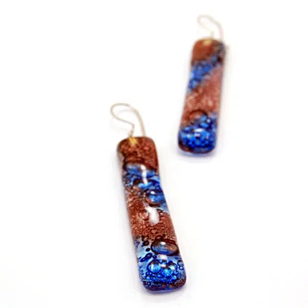 A close up picture of the naked art glass earrings, the color of this earring is brown/blue.