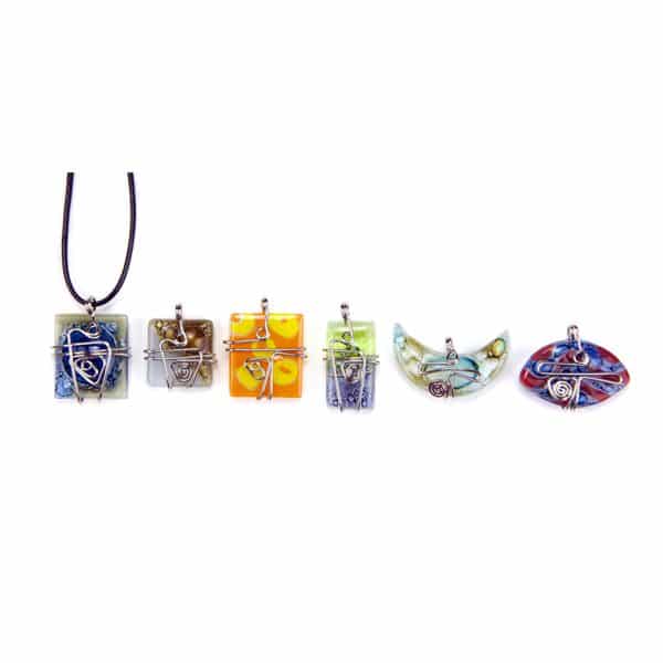 A picture of a bunch of different art glass necklaces, coming in a verity of colors.