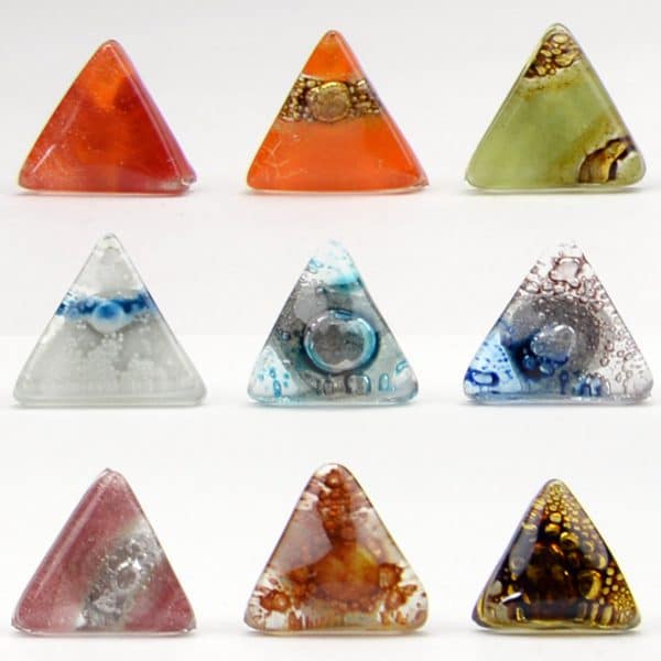 A picture of nine different art glass stud earrings, the colors in this picture are, red, orange, green, clear, clear/sky blue, clear/ dark blue, pink/ clear, clear/brown, and gold.
