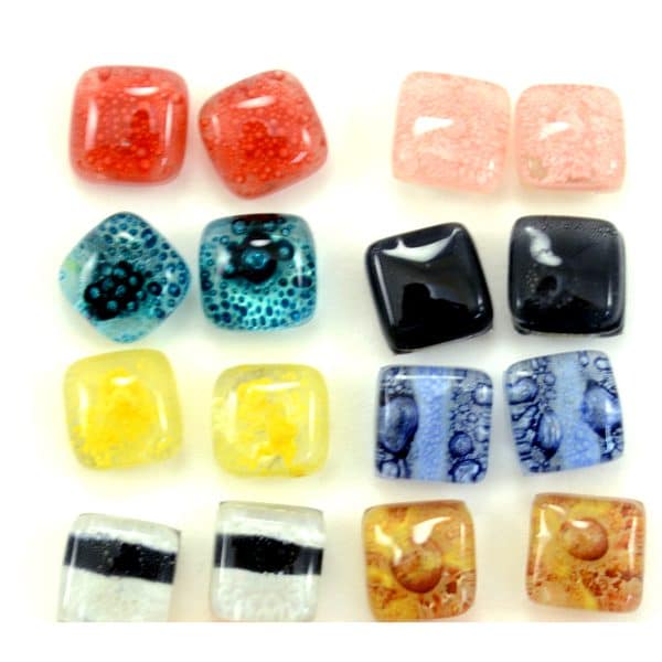A picture of a bunch of different colored glass stud earrings, the colors are, red, pink, sky blue, black, yellow, blue, clear, and gold.