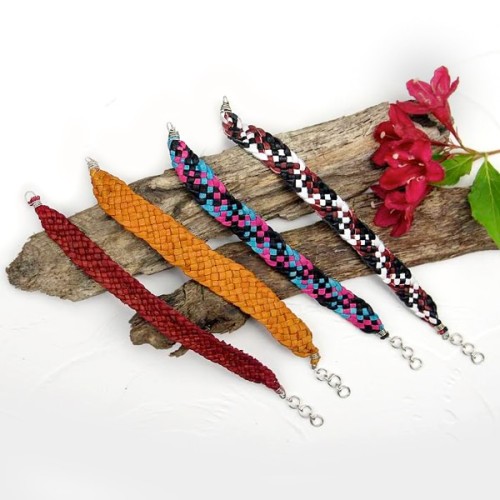 A picture of four different colors that the plait bracelet can come in, those colors are red, orange, pink/blue/black camo, and white/black/brown camo bracelet.