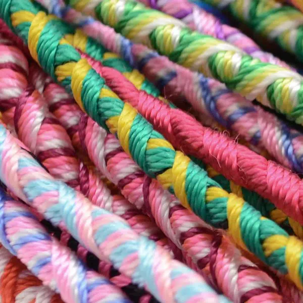 A close up picture of the tublar friendship bracelet, also showing all of the different colors and patterns.