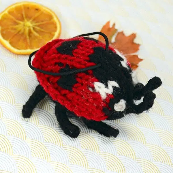 A catnip toy that looks like a lady bug, The toy has been hand knit with wool