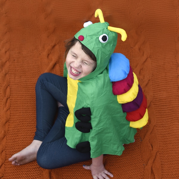 A young kid wearing a caterpillar play cape
