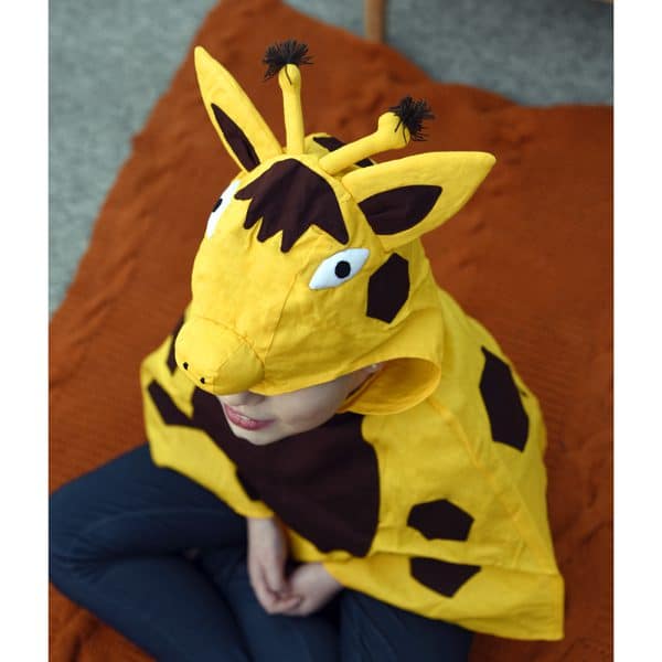 A young kid wearing a giraffe play cape