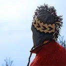 An adult wearing a hat with fabric running down the middle to give the hat a mohawk