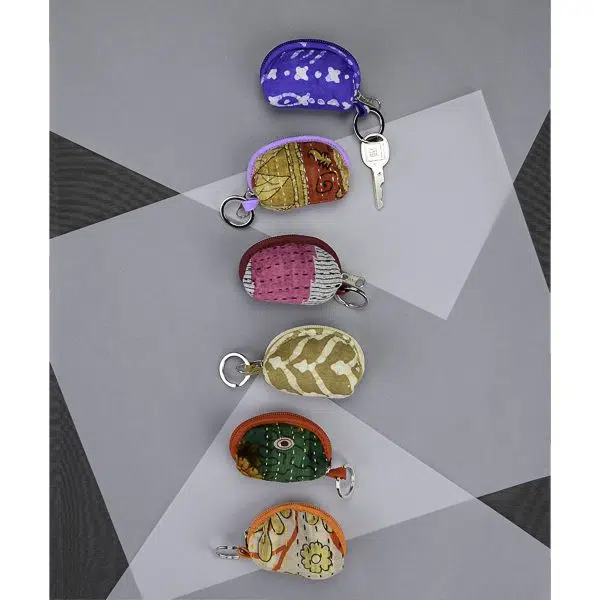 group of five different colors of the cotton purse keychain coming in five different colors, purple, yellow, pink, dark yellow, green, white