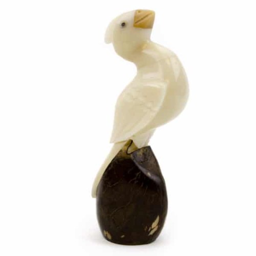 A cardinal that was hand carved out of a tagua nut, sitting on a tagua nut