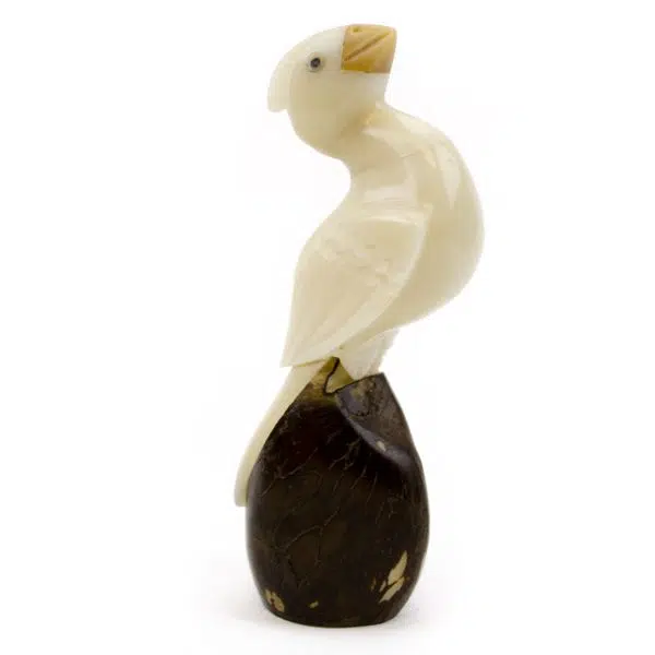 A cardinal that was hand carved out of a tagua nut, sitting on a tagua nut
