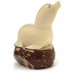 A seal sitting on a rock, hand carved from tagua seeds.