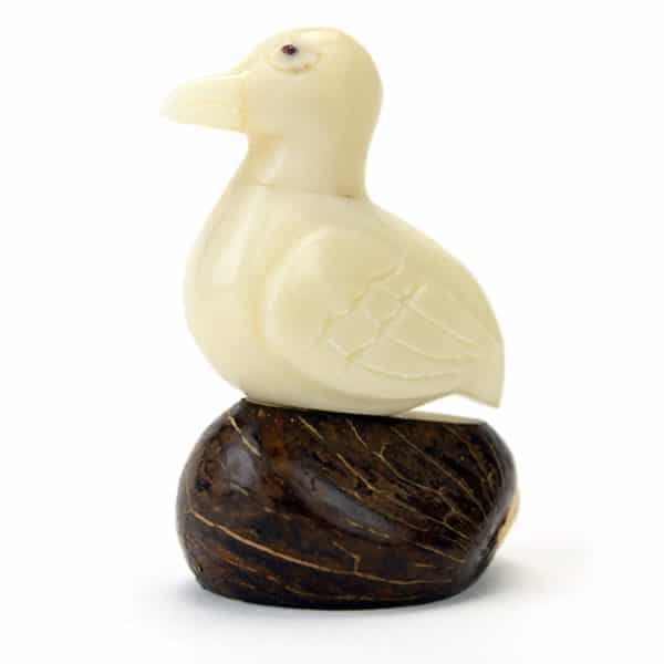 A duck hand carved from a tagua seed .