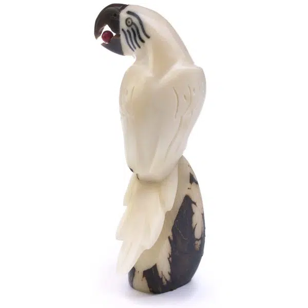 A hand carved parrot with a bead in its mouth